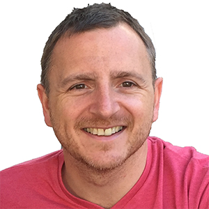 phil laviolette smiling wearing a peach v neck t shirt